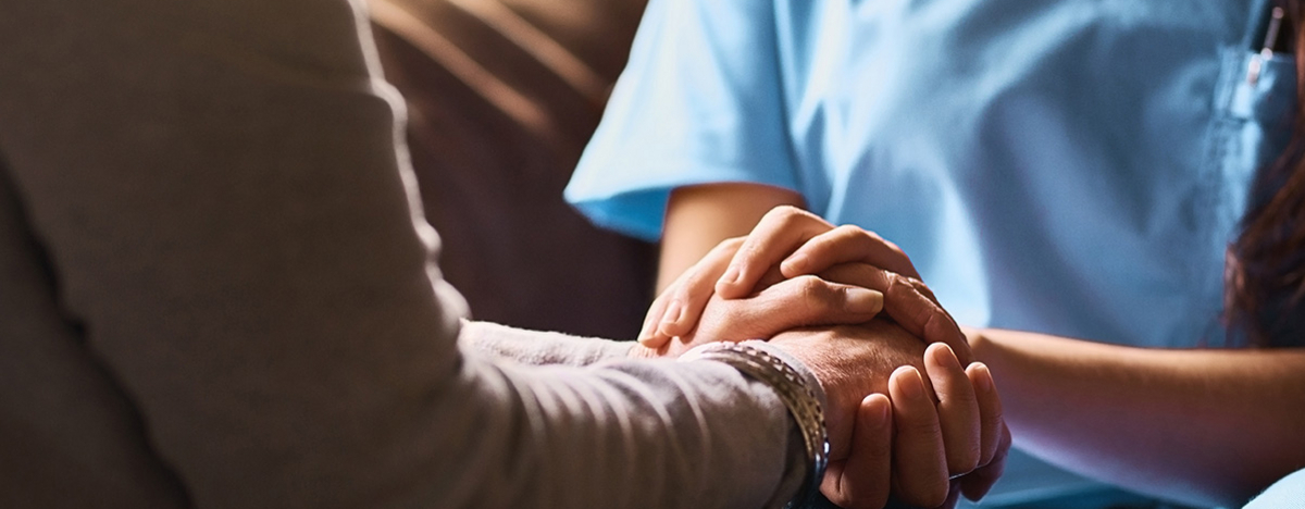 Pflegerin h&auml;lt die Hand eines &auml;lteren Menschen