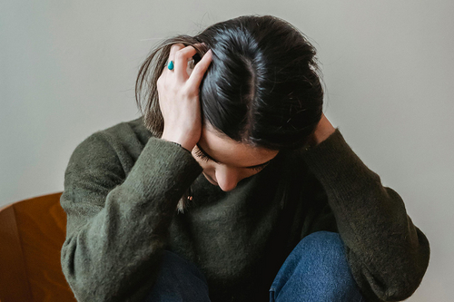 Frau w&uuml;hlt sich in den Haaren vor Angst