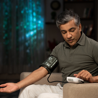 Ein &auml;lterer Mann, der seinen Blutdruck misst.