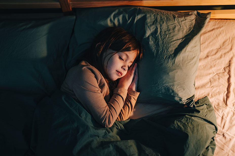 Kind schl&auml;ft im Bett
