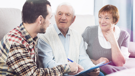 Ein j&uuml;ngerer Mann hilft einem &auml;lteren Herren beim Ausf&uuml;llen einer Betreuungsverf&uuml;gung