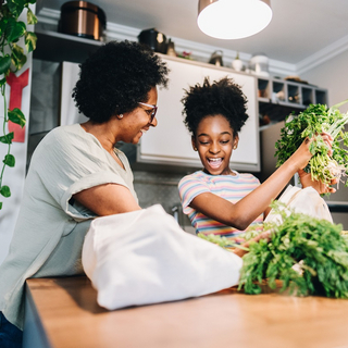Gesunde Lebensmittel werden von Mutter und Tochter nach dem Einkauf ausgepackt