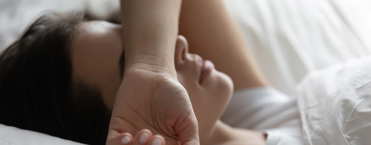 Frau, die ersch&ouml;pft im Bett liegt