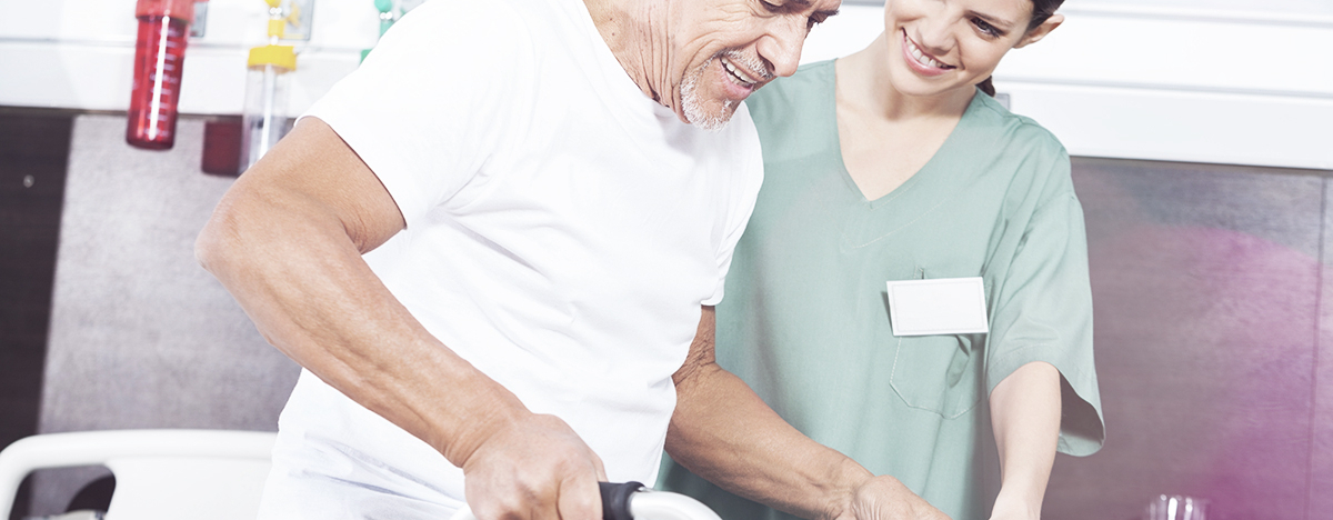 &Auml;lterer Mann an einer Gehilfe, betreut von einer Krankenschwester