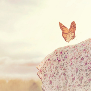 Schmetterling sitzt auf der Schulter einer Frau