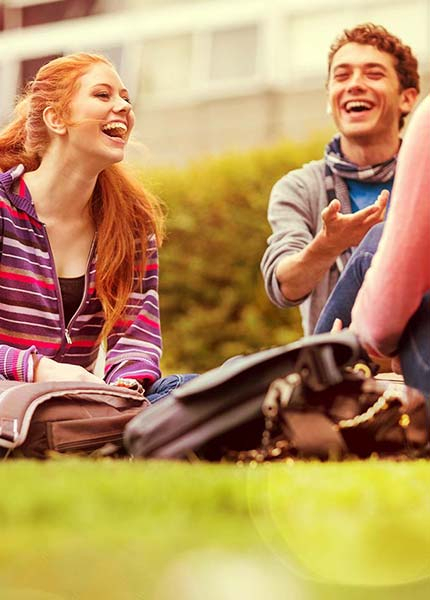 BKK VBU Lebensphase Studierende: lachende Studenten auf einer Wiese am Campus