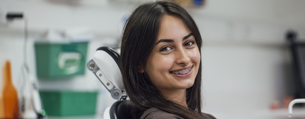 Eine Teenagerin mit Zahnspange ist in der Zahnarztpraxis, um sich die Z&auml;hne richten zu lassen.