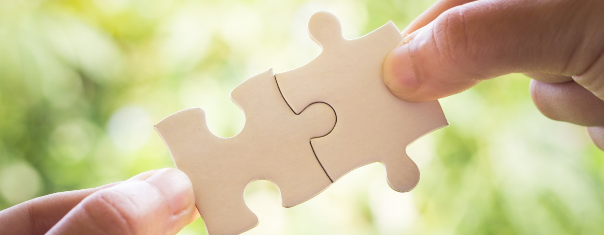 Zu sehen sind zwei H&auml;nde, die zwei passende Puzzleteile zusammenstecken.