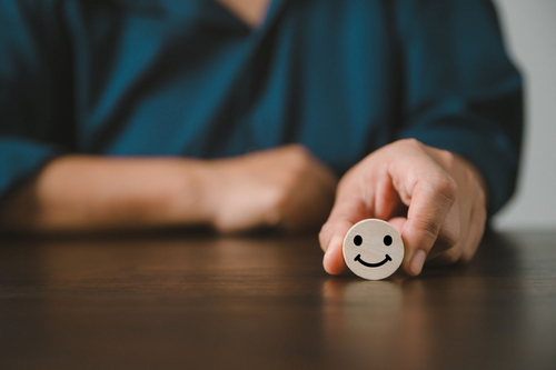 Frau h&auml;lt Smiley in der Hand