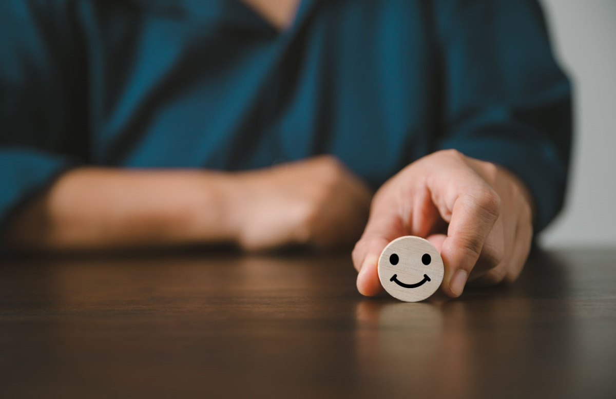 Frau h&auml;lt Smiley in der Hand