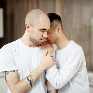 Zwei M&auml;nner in wei&szlig;en T-Shirts halten und unterst&uuml;tzen sich.