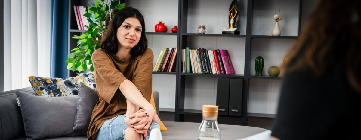 Junge Frau sitzt bei einem Psychotherapeuten