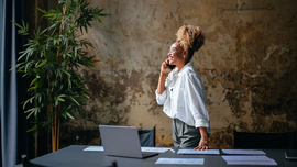 L&auml;chelnde Gesch&auml;ftsfrau, die auf einem Mobiltelefon spricht