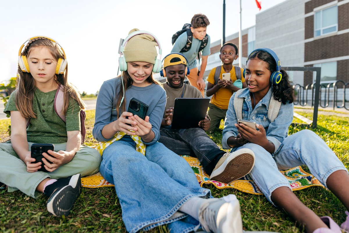 Kinder daddeln an ihrem Smartphone