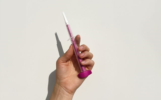 Hand mit einem Applikator