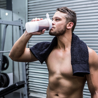 Ein muskul&ouml;ser Mann trinkt einen Proteinshake mit Kreatin.