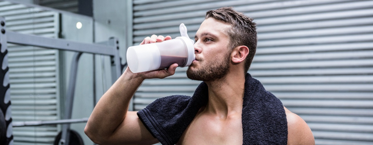 Ein muskul&ouml;ser Mann trinkt einen Proteinshake mit Kreatin.