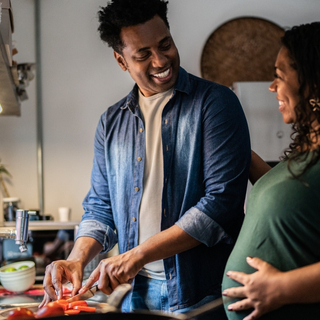 schwangere Frau und ihr Mann kochen zusammen