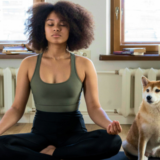 Eine Frau mit Hund meditiert.
