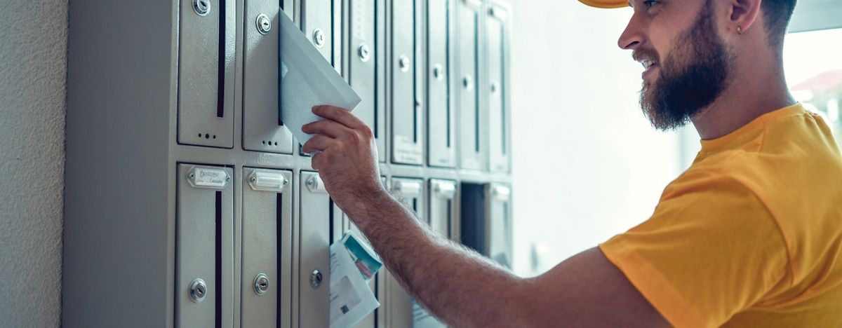 Postbote wirft Brief in Briefkasten