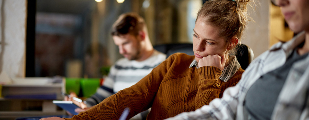 Gelangweilte Frau, die im B&uuml;ro am Laptop arbeitet.