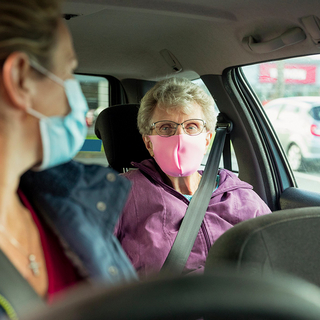 Pflegerin mit &auml;lterer Patientin im Auto