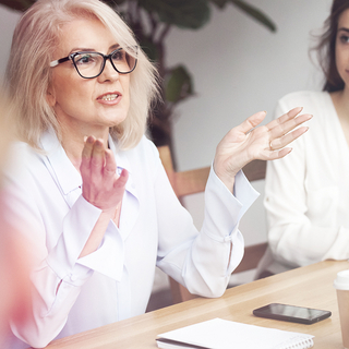Diskussionsrunde mehrerer Frauen am Tisch