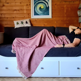 ME CFS Patienten liegt mit Decke und Augenmaske auf dem Sofa