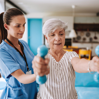Patientin macht zu Hause &Uuml;bungen mit Hanteln