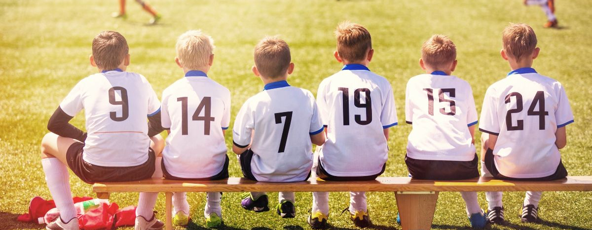 Jungs auf einer Auswechselbank beim Fu&szlig;ball