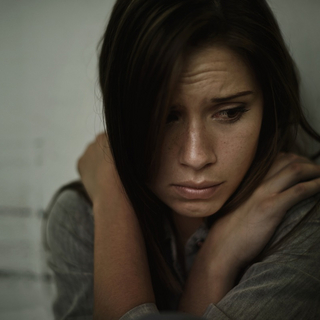 Eine junge Frau schaut traurig.