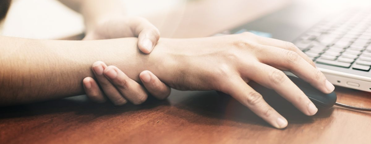Frau h&auml;lt sich das schmerzende Handgelenk