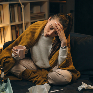 Eine junge Frau, die an einer Erk&auml;ltung leidet und sich unwohl f&uuml;hlt.