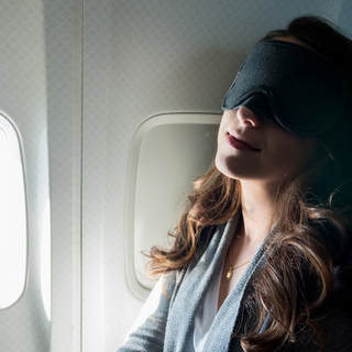 Frau schl&auml;ft im Flugzeug