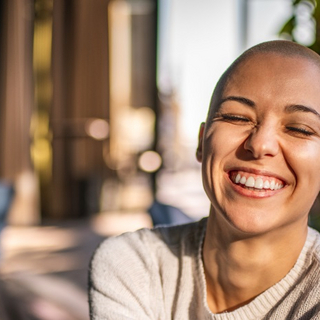 Portr&auml;t eines l&auml;chelnden M&auml;dchens mit kurzen Haaren und geschlossenen Augen