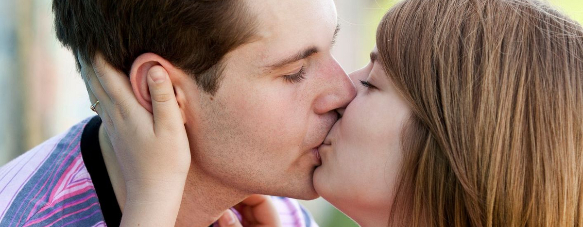 Junger Mann und junge Frau k&uuml;ssen sich