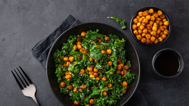 Ansicht einer Sch&uuml;ssel Gr&uuml;nkohlsalat mit Kichererbsen garniert