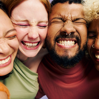 Vier Freunde lachen und zeigen ihre gesunden Z&auml;hne.