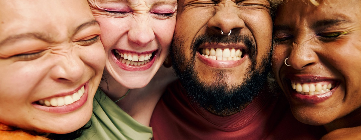 Vier Freunde lachen und zeigen ihre gesunden Z&auml;hne.