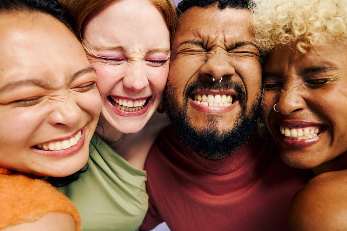 Vier Freunde lachen und zeigen ihre gesunden Z&auml;hne.