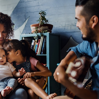 Vater spielt Gitarre, singt und hat Spa&szlig; mit seiner Familie